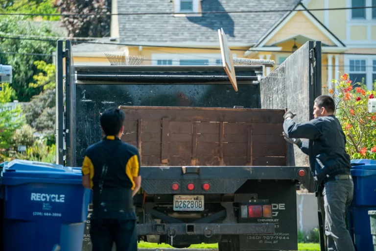 Junk B Gone Employee Hauling Bookcase Furniture Loading Into Black Truck - 99 Junk Removal