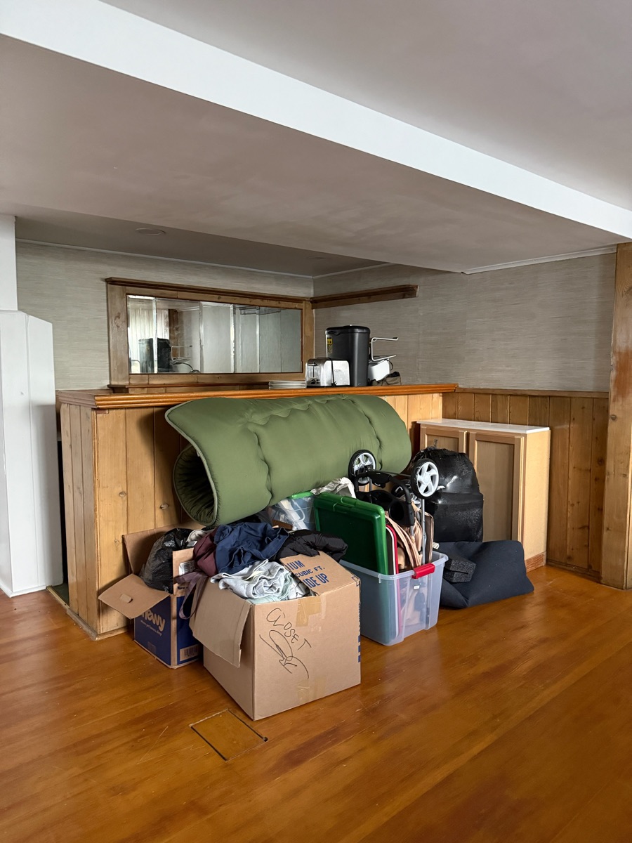 Before: cluttered basement rec room full of junk